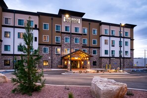 Experience the sleek design of this hotel, featuring a stone and stucco exterior with a uniform window pattern.