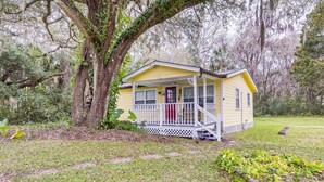 A yellow cabin with a porch, surrounded by trees and greenery. - 2 Mi to Marina: Inglis Retreat w/ Boat Parking (Inglis)