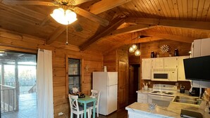 L’intérieur d’un chalet en bois comprend un coin repas, une cuisine et un balcon.