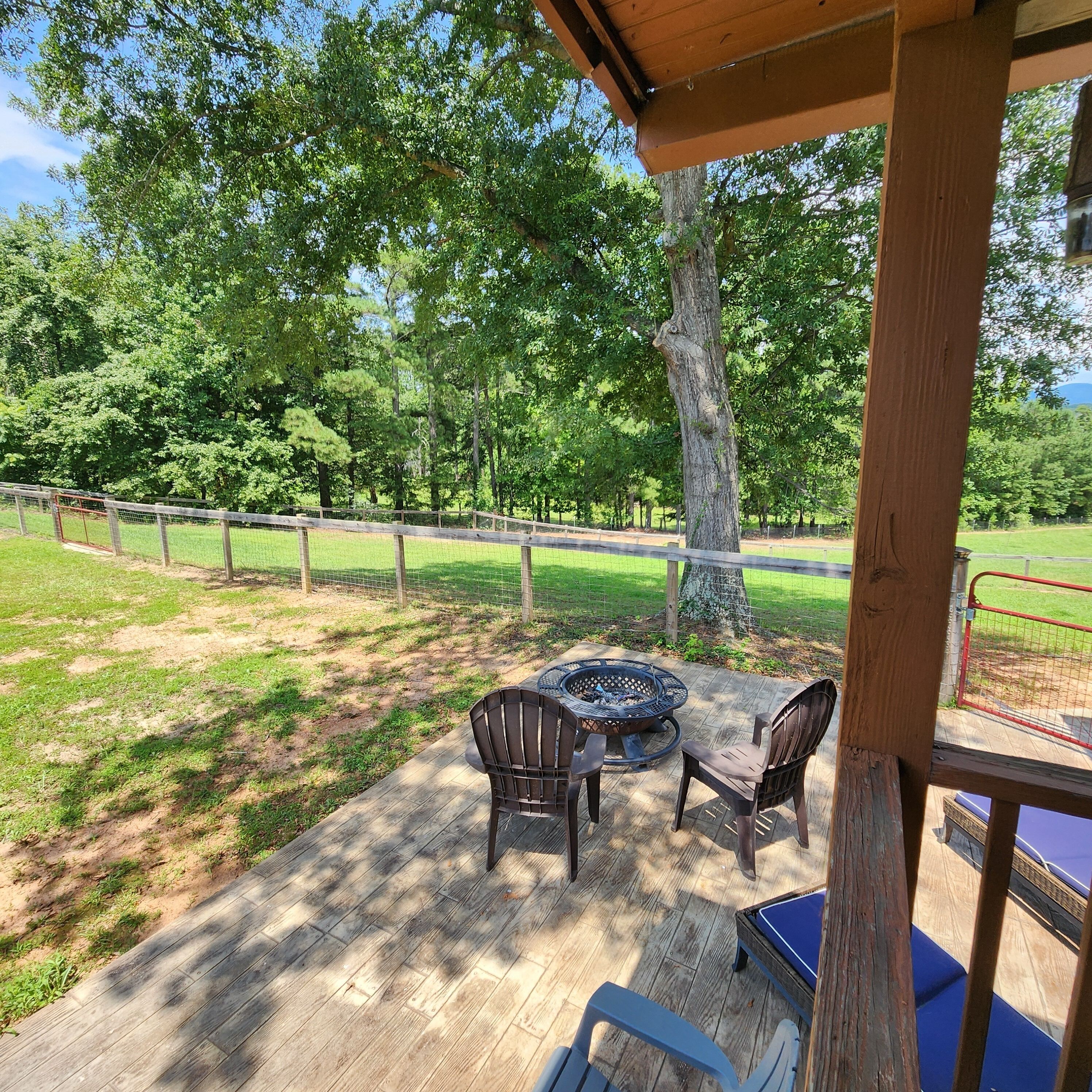 An outdoor patio with a fire pit, two chairs, and a table.