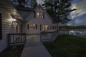 A two-story house with a deck and a lake view. - Luxury Historic Eagle River Chain Lake Estate *Summer Fri to Fri Only* (Eagle River)