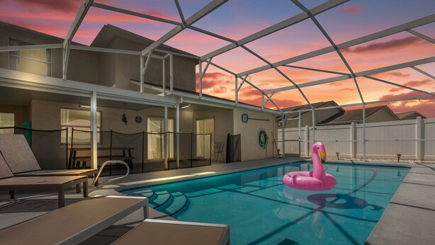 An indoor swimming pool with lounge chairs and a pink flamingo float. - Amazing Blue Private Pool - 4BR House Near Disney (Kissimmee)