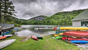 Un quai au bord du lac, où sont amarrés divers canoës et kayaks.