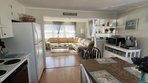 Cocina compacta con refrigerador, estufa y comedor. Un letrero en la pared dice "Jersey Shore".