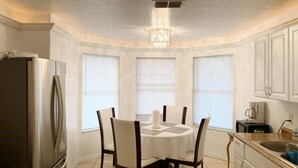A kitchen with a dining table, chairs, a refrigerator, and a chandelier. - GREAT HOME! GREAT LOCATION! PET FRIENDLY  (Kissimmee)