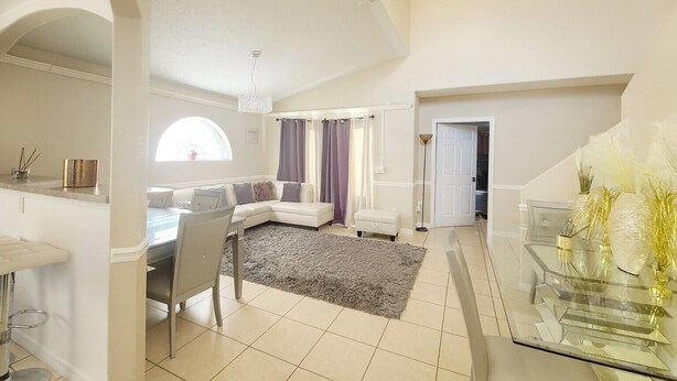 A spacious living area with a dining table, sofa, and a large window. - GREAT HOME! GREAT LOCATION! PET FRIENDLY  (Kissimmee)