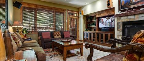 A cozy living room with a sofa, coffee table, and fireplace.