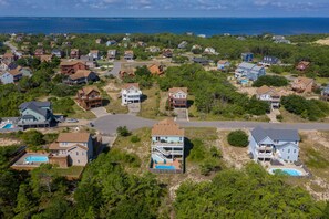 Área residencial com casas, uma rua e uma praia ao fundo.