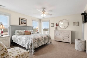 A bedroom with a bed, dresser, and ceiling fan. - Haven Of Rest: Private Saltwater Pool, Hot Tub, Game Room (Nags Head)