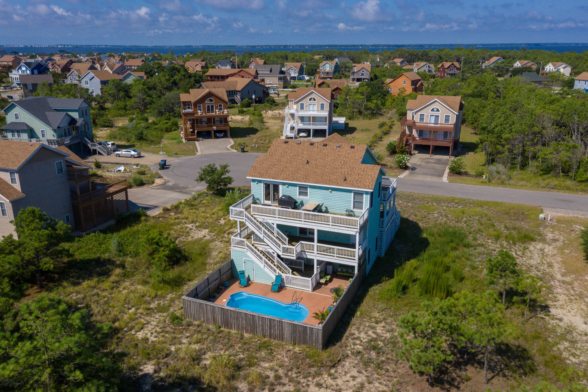 Ein zweistöckiges Haus mit Balkon und Swimmingpool.