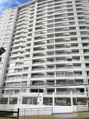 Un immeuble résidentiel de grande hauteur, doté de nombreux balcons, d’une entrée sécurisée et d’un numéro « 50 » bien visible sur la façade.