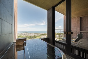 A modern indoor pool with a clear view of a cityscape and mountains in the background.