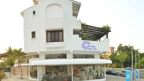 Un edificio blanco con un cartel que dice 'Hotel Suites Intapa Plaza'.