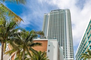A tall, modern hotel with a white facade and multiple balconies.