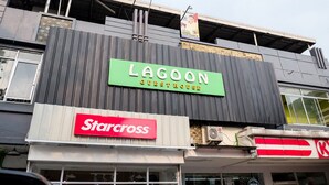 A building with a green sign reading "LAGOON GUESTHOUSE" and a red sign for "Starcross." - RedDoorz near Kebun Raya Bogor 2 (Bogor)