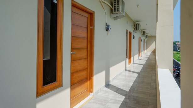 Un pasillo con puertas de madera y unidades de aire acondicionado en la pared.