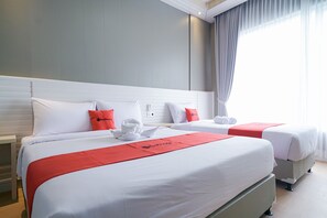 A hotel room with two beds, white bedding, red accents, and a view of the outdoors. - RedDoorz near Exit Toll Sirkuit Sentul (Bogor)