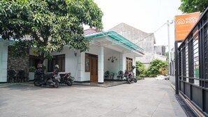 A building with a covered entrance, several motorcycles parked outside, and a sign advertising 'Kool Kost'. - KoolKost @ Batutulis Bogor (Bogor)