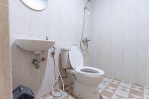 A bathroom with a toilet, sink, and shower.