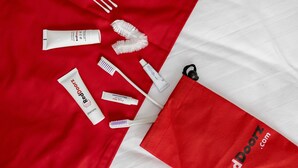 A neatly arranged set of personal care items on a red and white fabric background.