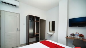 A hotel room with a bed, a wardrobe, a bathroom with a sink, and a TV mounted on the wall.