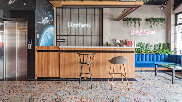 A modern bar area with a wooden counter, two stools, and a neon sign reading "sleep is love". - RedDoorz Plus @ Doorman Guest House (Bandung)