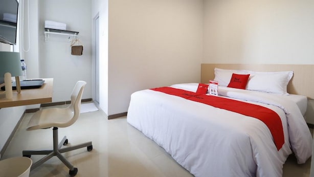 A hotel room with a bed, a desk, a chair, and a small table. - RedDoorz Plus Syariah near Mall Pondok Indah (Jakarta)