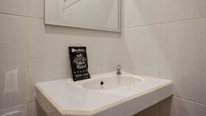 A bathroom with a white sink, a mirror, and a RedDooz sleep travel bag on the counter. - RedDoorz @ Losari Area 2 (Makassar)