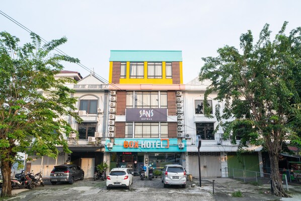 A multi-story building with a "Box Hotel" sign, a "Sans Hotels" sign above, and a "NO Parking" sign on the ground floor.