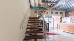 A staircase with wooden steps and metal railings, leading to an upper floor.