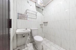 Une salle de bain avec des toilettes, un lavabo et une douche.