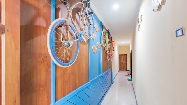A hallway with bicycles mounted on the wall and a blue bench along the corridor.