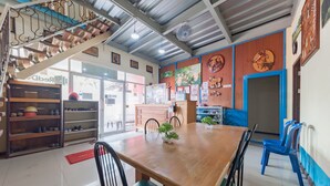 A dining area with a wooden table, chairs, and a staircase.