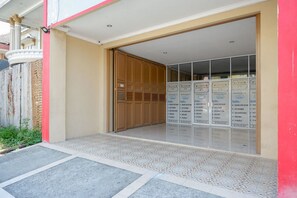 Entrada de hotel con piso de baldosas, puerta de madera y puerta de vidrio que da a una habitación con vistas.