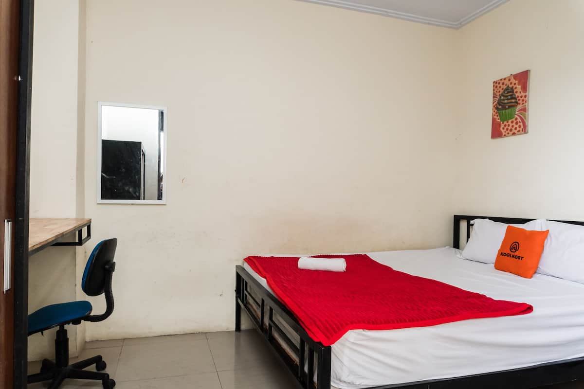 Een slaapkamer met een bed, een bureau en een stoel.