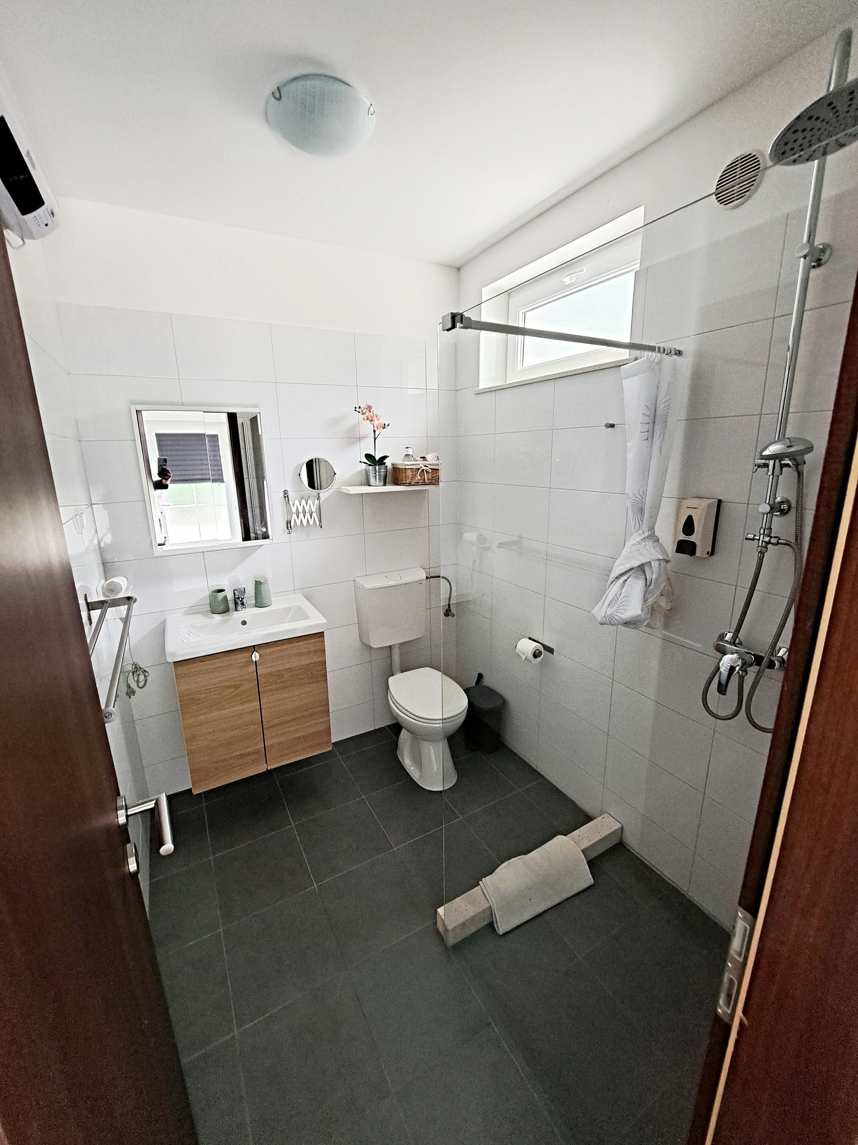 A modern bathroom with a toilet, sink, and shower.