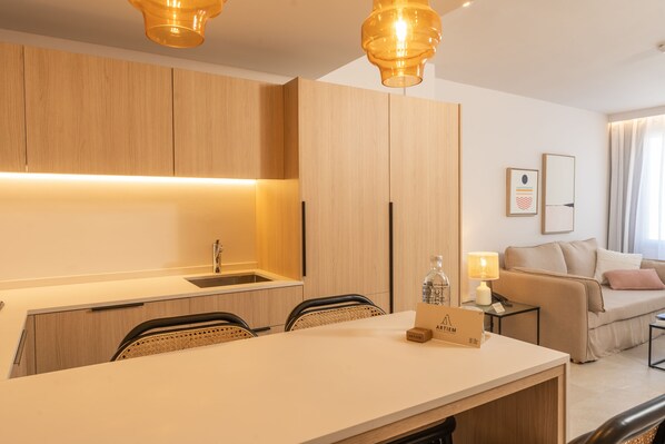 A modern kitchen with wooden cabinets, a white countertop, and two pendant lights.