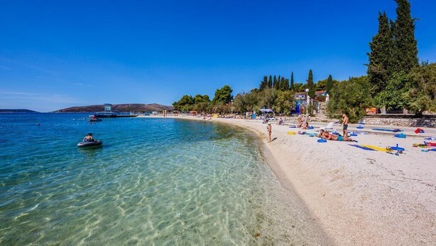 A beach with clear water, a sandy shore, and a few people. - Mix of modern and antique , New visage villa Antico (Seget Donji)