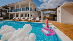 A modern villa with a swimming pool, sun loungers, and a wooden deck. - Mix of modern and antique , New visage villa Antico (Seget Donji)