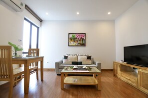 Habitación Deluxe | Sala de estar | Televisión de pantalla plana de 33 pulgadas con canales por cable