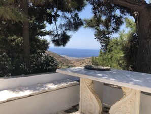 A terrace with a view of the sea, surrounded by trees and a white balustrade. - Semeli Arthouse - Amazing view (Tinos)