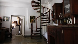 Una habitación con escalera de caracol, muebles de madera y una cama.