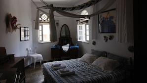 Un dormitorio con cama, una silla, un escritorio y un espejo.