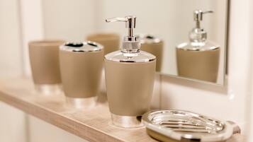 Un mobile bagno con specchio, un dispenser di sapone e un portasapone.