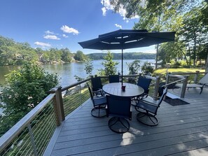Une terrasse avec une table et des chaises, donnant sur un lac.