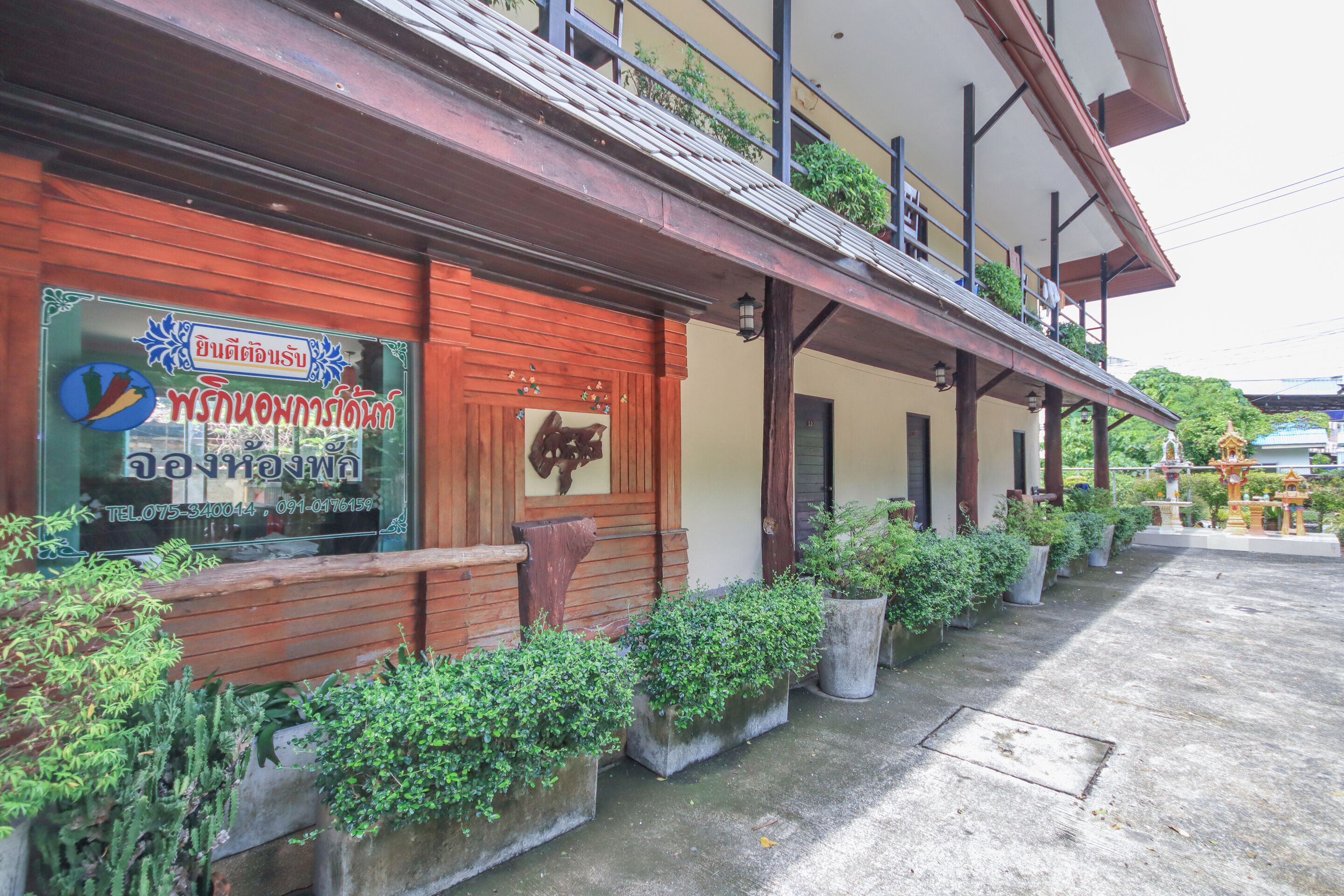 A building with a red facade, wooden benches, and potted plants.