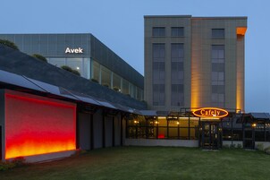 Un edificio moderno con una cafetería llamada "CafeLy" y un letrero que dice "Avek".