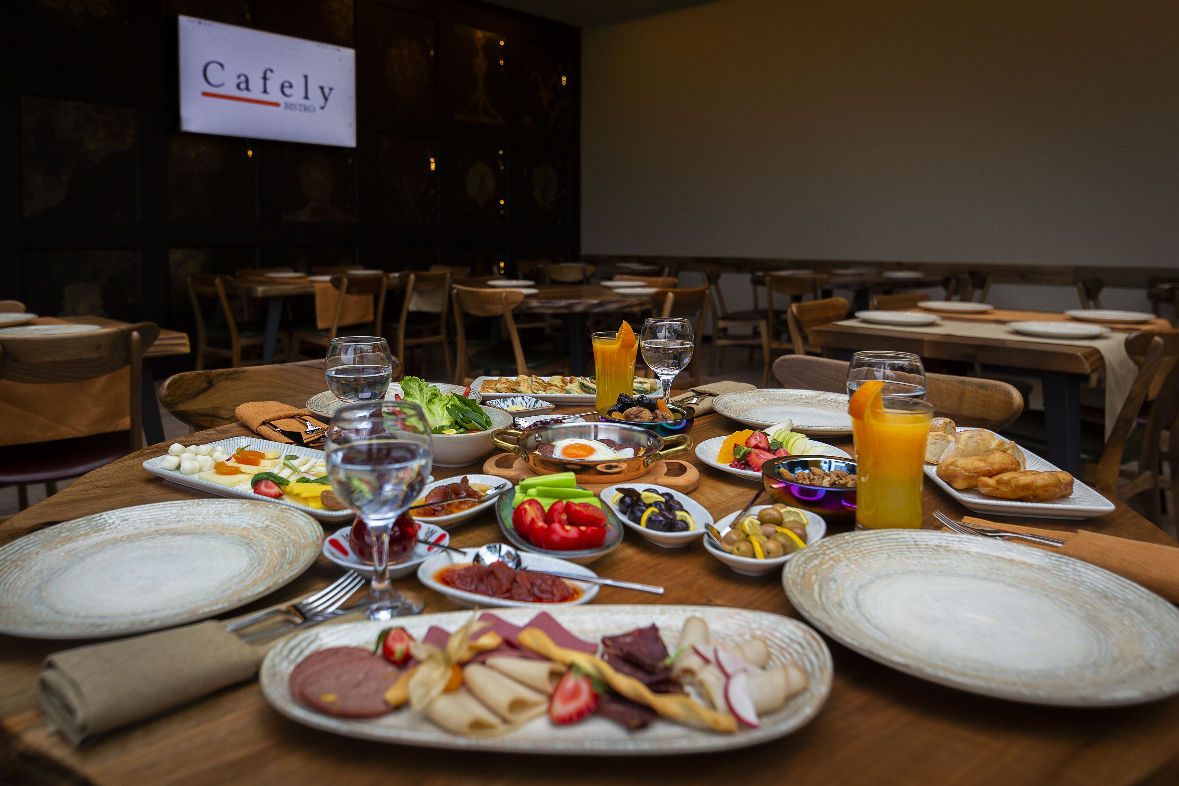 Une table à manger dressée avec différents plats, verres et couverts, ce qui suggère qu’il s’agit d’un restaurant.