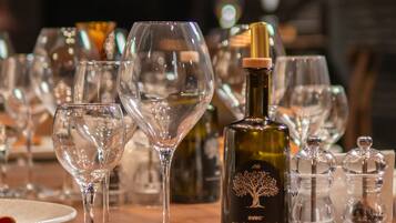 A table set with wine glasses, a bottle of wine, and salt and pepper shakers.