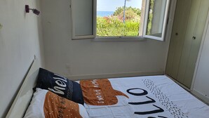 A bedroom with a bed, a window, and a view of the outdoors. - 3 bedroom house 90m² Hyères the sea is 50 meters from the beach (Hyères)